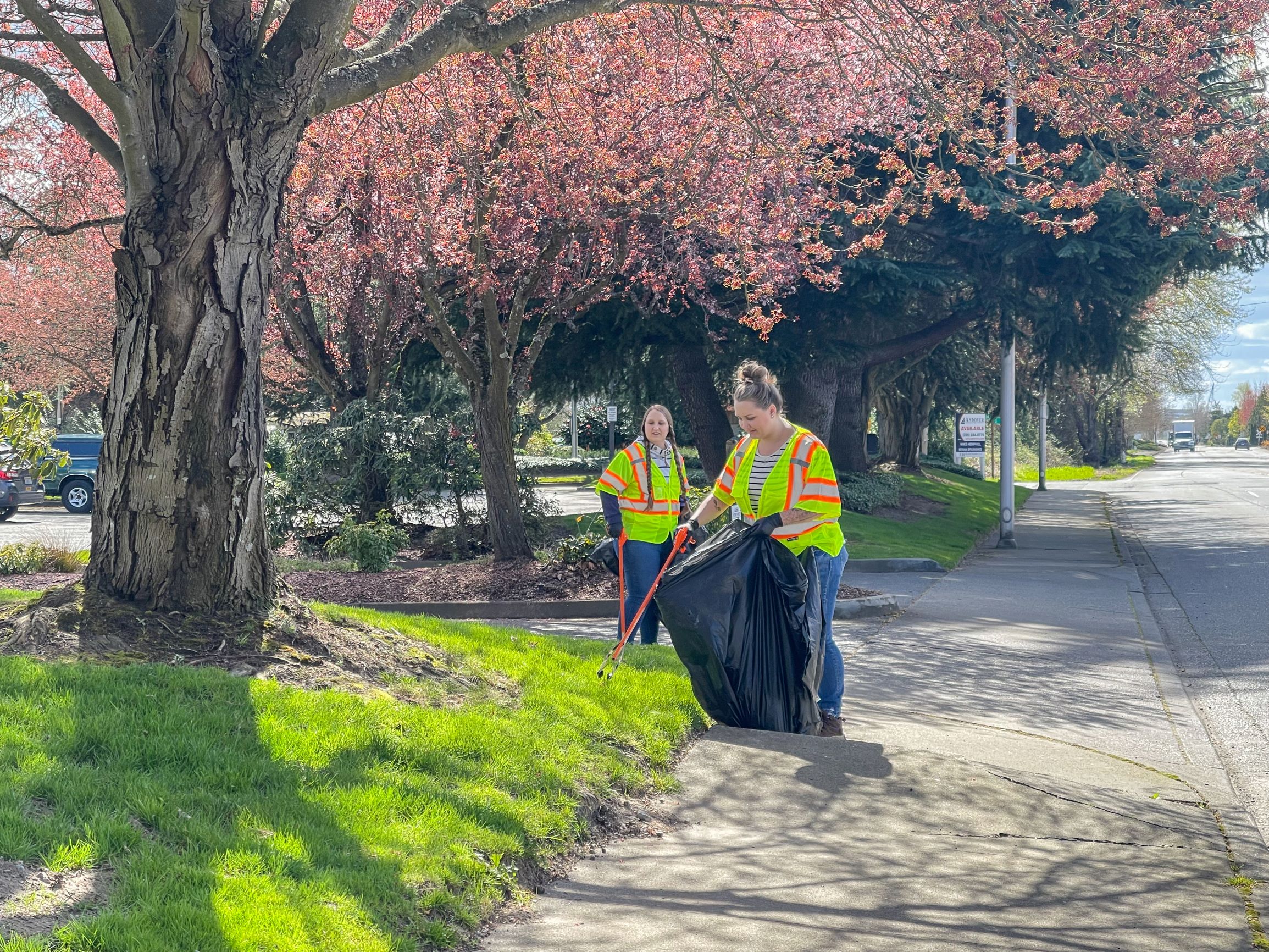 Two Barghausen employees volunteering to pick up trash on the side of the road.